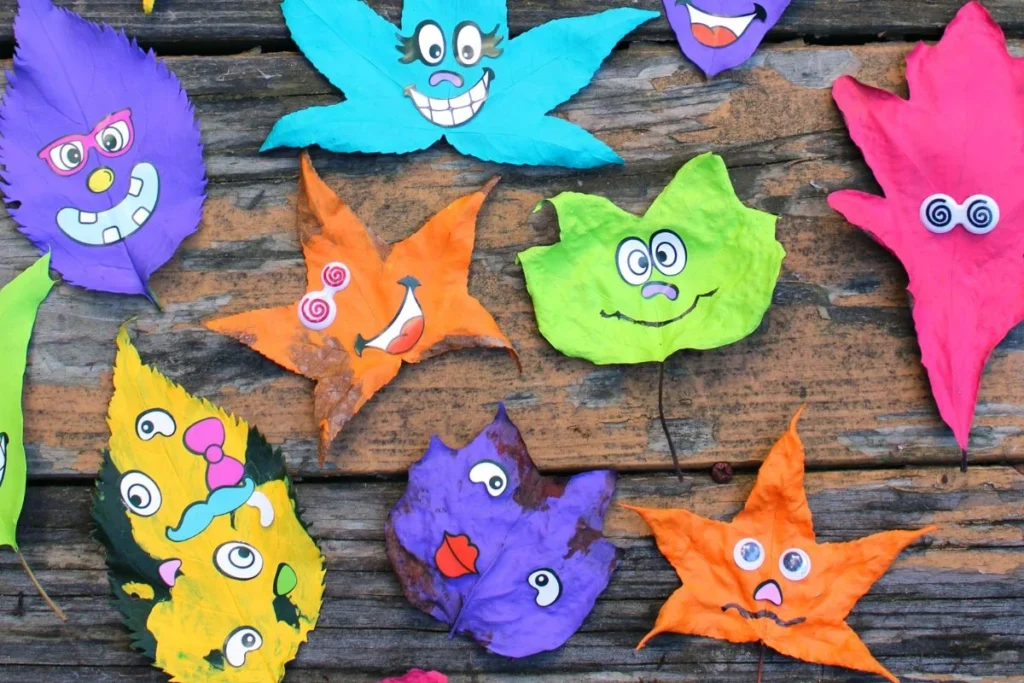 A collection of monster leaf art with leaves panted in bright solid colors with silly face stickers on top. 